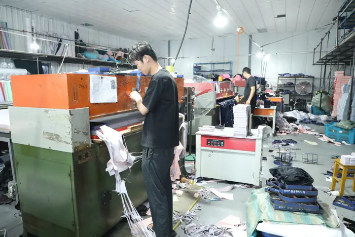 Operator at a hydraulic die-cutting station cutting bag components